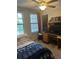 Bedroom featuring a ceiling fan, two windows and a study desk at 17361 Old Tobacco Rd, Lutz, FL 33558