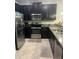 Kitchen featuring black cabinetry, stainless appliances, and granite countertops at 17361 Old Tobacco Rd, Lutz, FL 33558