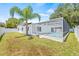 Backyard view of the pool, white exterior, and well-maintained lawn and tropical landscaping at 1901 76Th N Ave, St Petersburg, FL 33702
