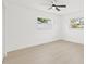 Bright bedroom featuring two windows, ceiling fan, and light wood-look flooring at 1901 76Th N Ave, St Petersburg, FL 33702