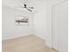 Bedroom featuring ceiling fan, closet, window, and light wood-look flooring at 1901 76Th N Ave, St Petersburg, FL 33702