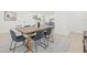 Sunlit dining area features a wooden table, modern chairs, light wood floors, and neutral color palette at 1901 76Th N Ave, St Petersburg, FL 33702