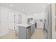 Bright and airy kitchen showcasing white cabinets, a gray island, stainless steel appliances, and wood flooring at 1901 76Th N Ave, St Petersburg, FL 33702