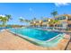 Community pool with lounge chairs, umbrellas, and tropical landscaping at 19417 Gulf Blvd # B110, Indian Rocks Beach, FL 33785