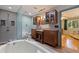 Bathroom featuring a soaking tub, walk-in shower, granite countertops and dark wood cabinets at 211 60Th S Ave, St Petersburg, FL 33705