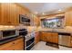 Functional kitchen showcasing stainless steel appliances and natural-wood cabinetry at 211 60Th S Ave, St Petersburg, FL 33705