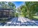 Well-manicured backyard features a screened-in area, stepping stone walkway, and a fenced-in lawn at 2201 Horan S Way, Gulfport, FL 33707