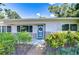 Inviting front porch with vibrant plants, a blue door, and clear house numbers for easy identification at 2201 Horan S Way, Gulfport, FL 33707