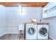Well-lit laundry room features modern washer, dryer, sink, wood countertop and convenient storage shelves at 2201 Horan S Way, Gulfport, FL 33707