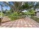 Spacious backyard featuring a unique checkered tile patio, mature trees, and partially fenced yard at 2221 W Lake Dr, Wimauma, FL 33598