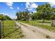 Gated entrance and long driveway leading to the home on a spacious lot with mature trees and plenty of privacy at 2221 W Lake Dr, Wimauma, FL 33598