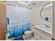 Bright bathroom featuring a shower with a blue shower curtain and an updated vanity at 2240 Pinewood Villas Dr, Holiday, FL 34691