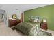 Comfortable bedroom with olive green bedding, wood furniture, and an accent wall at 2240 Pinewood Villas Dr, Holiday, FL 34691