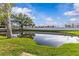 Scenic community pond with a view of the houses reflected on the water at 2240 Pinewood Villas Dr, Holiday, FL 34691