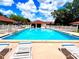 Large community pool on a sunny day features lounge chairs and a clubhouse with a red tile roof at 2460 Northside Dr # 708, Clearwater, FL 33761