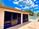 Exterior view of the pool clubhouse, featuring dark screened windows and a view of the pool at 2460 Northside Dr # 708, Clearwater, FL 33761