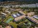 Aerial view of a community with greenery, buildings, parking, and tennis courts at 2700 Bayshore Blvd # 1206, Dunedin, FL 34698