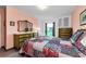 Bedroom featuring a colorful quilt, a large window with backyard view, and dresser at 2700 Bayshore Blvd # 1206, Dunedin, FL 34698