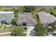 Aerial view of home featuring a screened-in pool, manicured lawn, and mature landscaping at 27826 Sora Blvd, Wesley Chapel, FL 33544