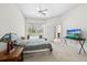 Bedroom features a sliding glass door leading to the pool area, ceiling fan, and TV at 27826 Sora Blvd, Wesley Chapel, FL 33544