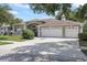 Charming single-story home featuring a well-manicured lawn and a three-car garage at 27826 Sora Blvd, Wesley Chapel, FL 33544