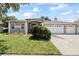 Charming single-story home featuring a well-manicured lawn and a three-car garage at 27826 Sora Blvd, Wesley Chapel, FL 33544