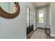 Stylish entryway featuring a decorative mirror, frosted-glass closet door, and a bench at 3037 Riders Pass, Odessa, FL 33556