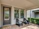 Inviting front porch with comfortable chairs, a cozy welcome mat, and a stylish front door at 3037 Riders Pass, Odessa, FL 33556