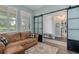 Cozy living room featuring a comfortable couch, black barn door, and natural lighting at 3037 Riders Pass, Odessa, FL 33556