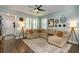 Bright living room with a comfortable sectional sofa, decorative mirrors, and plantation shutters at 3037 Riders Pass, Odessa, FL 33556