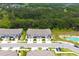 New townhomes featuring driveways, garages, and a community pond with lush green spaces at 30798 Veridian Way, Wesley Chapel, FL 33543
