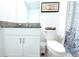 Well-lit bathroom featuring a toilet, vanity with countertop, framed art, and a patterned shower curtain at 30798 Veridian Way, Wesley Chapel, FL 33543