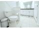Bright bathroom featuring a toilet, white vanity with granite countertop, and neutral-toned tile flooring at 30798 Veridian Way, Wesley Chapel, FL 33543