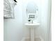 Clean bathroom featuring a pedestal sink, oval mirror, decorative plant, and neutral decor at 30798 Veridian Way, Wesley Chapel, FL 33543