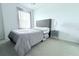 Bedroom features a plush bed with a tufted headboard, a side table, and soft carpeting at 30798 Veridian Way, Wesley Chapel, FL 33543