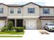 Inviting townhome exterior features a garage, well-manicured lawn and a covered entryway at 30798 Veridian Way, Wesley Chapel, FL 33543