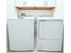 Functional laundry area with a white washer and dryer set against white walls and tile flooring at 30798 Veridian Way, Wesley Chapel, FL 33543