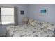 Cozy bedroom with a floral-patterned bedspread and a bright window at 3200 Cove Cay Dr # 5F, Clearwater, FL 33760