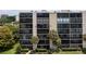 View of the building, showcasing multiple units with balconies, enhanced by lush, tropical palm trees at 3200 Cove Cay Dr # 5F, Clearwater, FL 33760