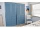Bedroom with blue closet doors, chair, and seaside artwork at 3200 Cove Cay Dr # 5F, Clearwater, FL 33760