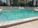 Community pool with a white fence and tiled border, ensuring a safe and enjoyable swimming experience at 3200 Cove Cay Dr # 5F, Clearwater, FL 33760