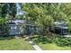 Charming single-story home with a covered porch, mature trees, and driveway at 3317 15Th N St, St Petersburg, FL 33704
