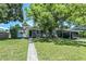 Charming single-story home with a covered carport and mature trees in a lush front yard at 3317 15Th N St, St Petersburg, FL 33704