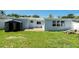 The home features a spacious backyard with a checkered tile patio and well-maintained lawn at 3509 Brookston Dr, Holiday, FL 34691