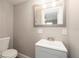 Modern bathroom with a toilet and sink set against a neutral backdrop at 3509 Brookston Dr, Holiday, FL 34691