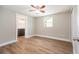 Cozy bedroom featuring wood floors, a ceiling fan, and a view into the Primary bathroom at 3509 Brookston Dr, Holiday, FL 34691