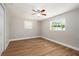 Bright bedroom with neutral tones, featuring wood-look floors and ample natural light streaming through the windows at 3509 Brookston Dr, Holiday, FL 34691