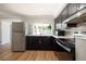 Well-lit kitchen with stainless steel appliances, dark cabinetry, and modern finishes at 3509 Brookston Dr, Holiday, FL 34691