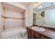 Bathroom featuring a vanity with wood-look cabinets and a shower-tub combo with tiled walls at 5265 E Bay Dr # 521, Clearwater, FL 33764
