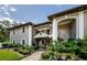 Charming two-story building featuring a covered entry, balcony, decorative railings, and lush landscaping at 5265 E Bay Dr # 521, Clearwater, FL 33764